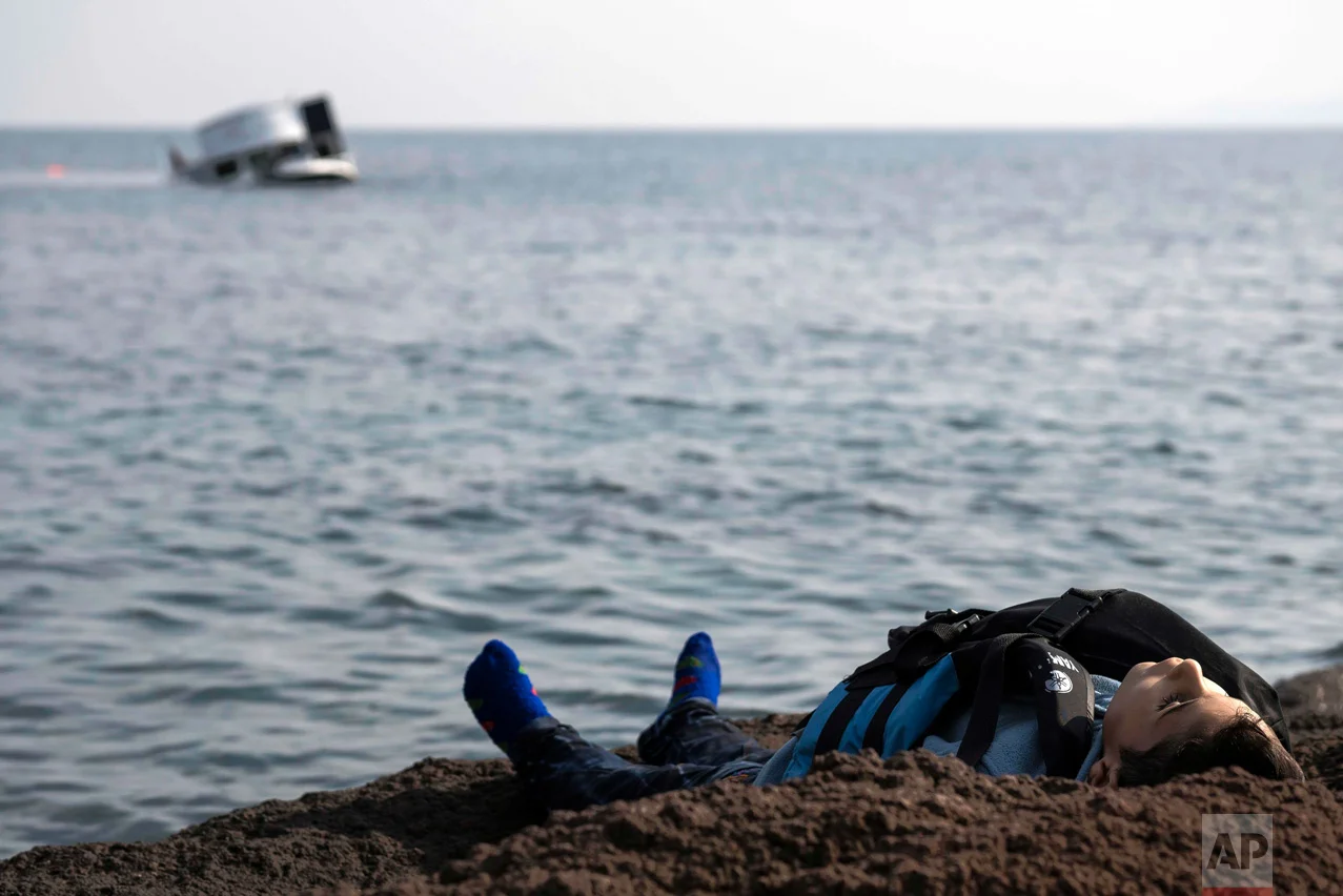 The dead body of a migrant boy lies on the beach near the Aegean town of Ayvacik, Canakkale, Turkey, on Jan. 30, 2016. A boat carrying migrants to Greece hit rocks off the Turkish coast and capsized, killing at least 33 people, including five children, officials and news reports said. (AP Photo/Halit Onur Sandal)