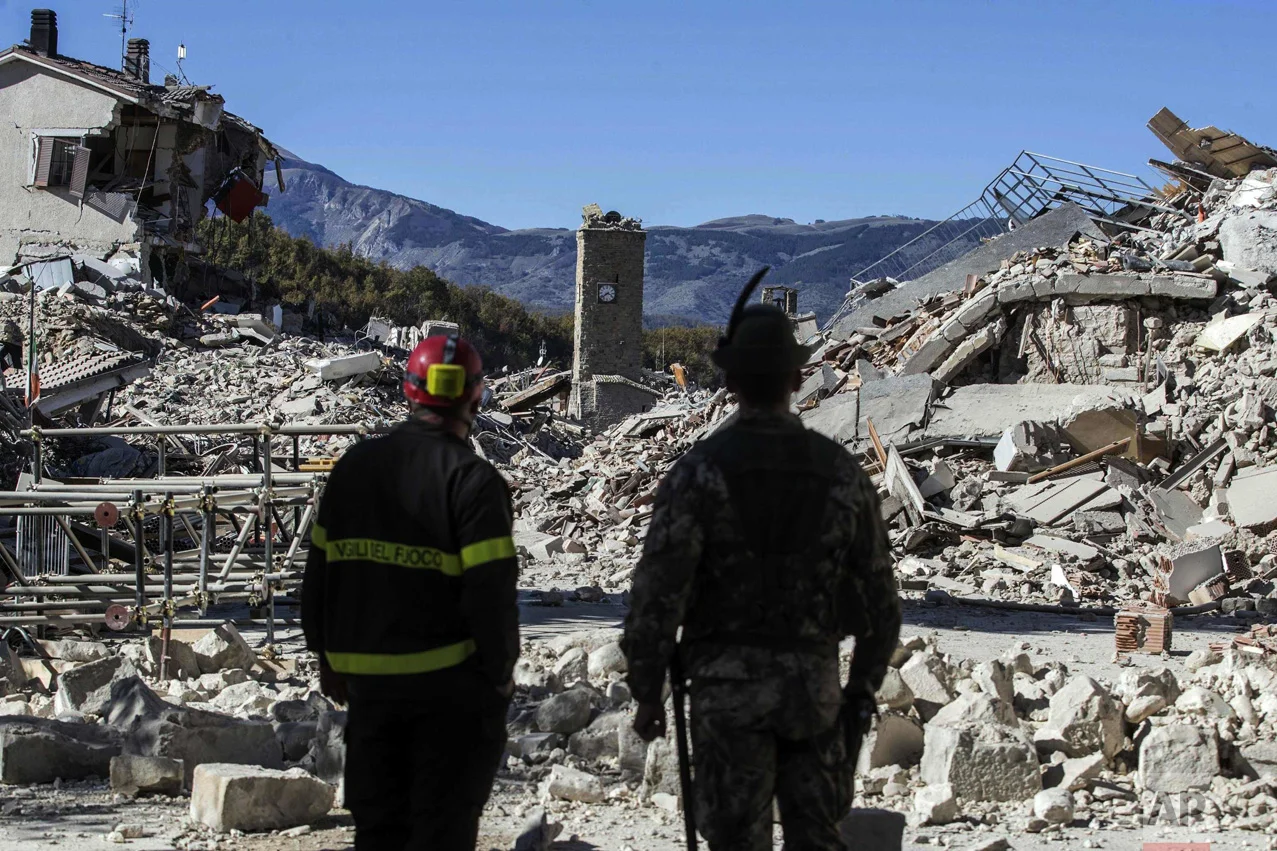 A firefighter, left, and an alpine soldier look at rubble in the hilltop town of Amatrice after an earthquake with a preliminary magnitude of 6.6 struck central Italy on Oct. 30, 2016. The powerful earthquake rocked the same area of central and southern Italy hit by a quake in August, and a pair of aftershocks just a week prior to this one sent already quake-damaged buildings crumbling after a week of temblors that have left thousands homeless. (Massimo Percossi/ANSA via AP)