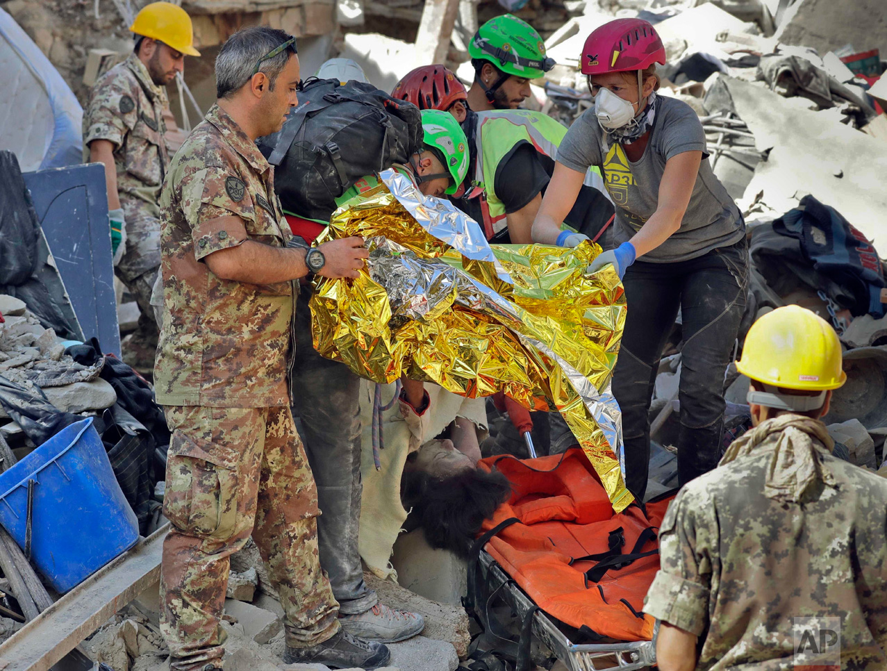  In this Wednesday, Aug. 24, 2016 photo, the body of a victim is pulled out of the rubble following an earthquake in Amatrice Italy. The magnitude 6 quake struck at 3:36 a.m. (0136 GMT) and was felt across a broad swath of central Italy, including Ro