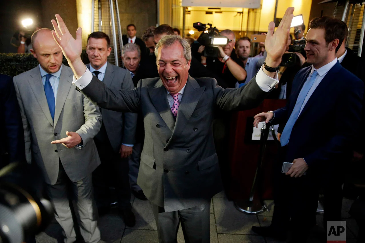 In this Friday, June 24, 2016 photo, Nigel Farage, the leader of the UK Independence Party, celebrates as he poses for photographers as he leaves a "Leave.EU" organization party for the British European Union membership referendum in London. The British people voted by 52% in favour of leaving the European Union in the referendum on June 23. (AP Photo/Matt Dunham)