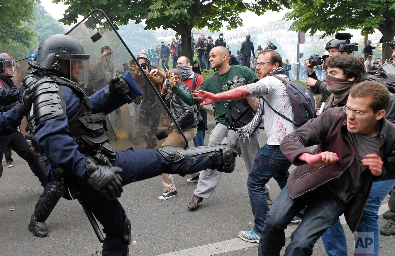 In this Thursday, May 26, 2016 photo, riot police officers clash with protestors during a demonstration held as part of nationwide labor actions in Paris, France. (AP Photo/Francois Mori)