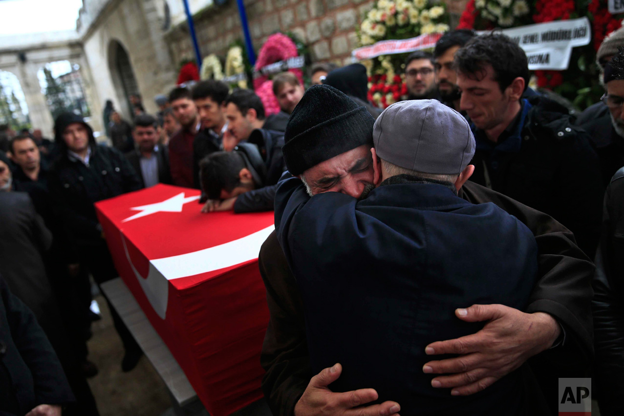  In this Tuesday, March 15, 2016 photo, Mustafa Alan, centre, the father of Mehmet Alan, 29, killed at Sunday's explosion in Ankara, embraces a mourner next to his son's coffin, during the funeral procession at Fatih Mosque n Istanbul. The blast whic