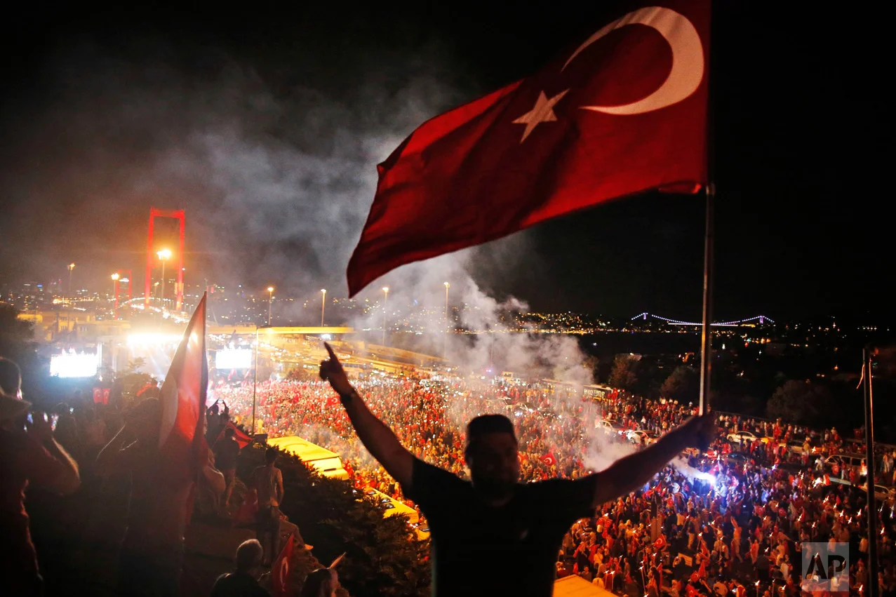In this Thursday, July 21, 2016 photo, pro-government supporters protest on the road leading to Istanbul's iconic Bosporus Bridge, background left. Turkish lawmakers approved a three-month state of emergency, endorsing new powers for Turkey's President Recep Tayyip Erdogan that would allow him to expand a crackdown in the wake of the July 15 failed coup. (AP Photo/Emrah Gurel)