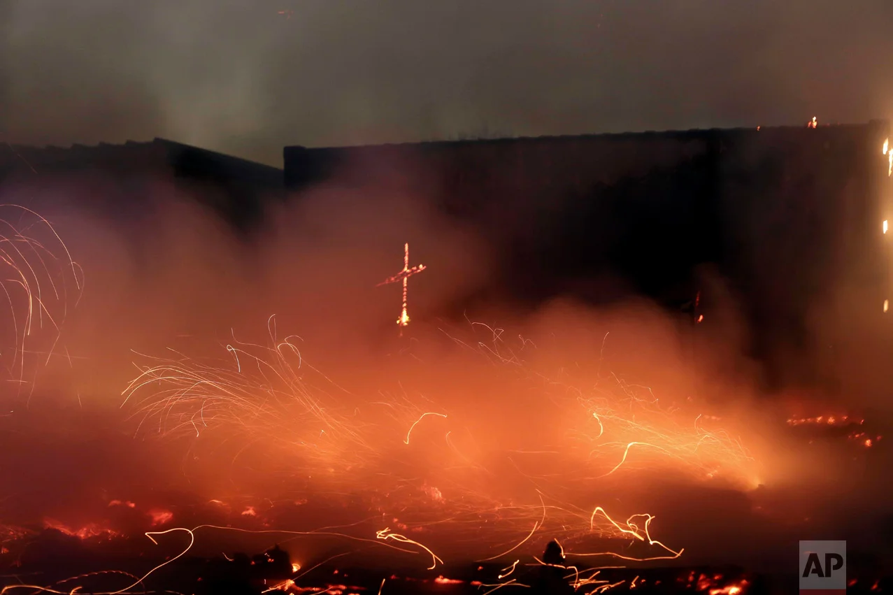 In this Tuesday, Oct. 25, 2016 photo, fires burn in the makeshift migrant camp known as "the jungle" near Calais, northern France. Crews have started dismantling the squalid migrant camp in France after the process to clear the camp began in earnest on Monday. (AP Photo/Thibault Camus)
