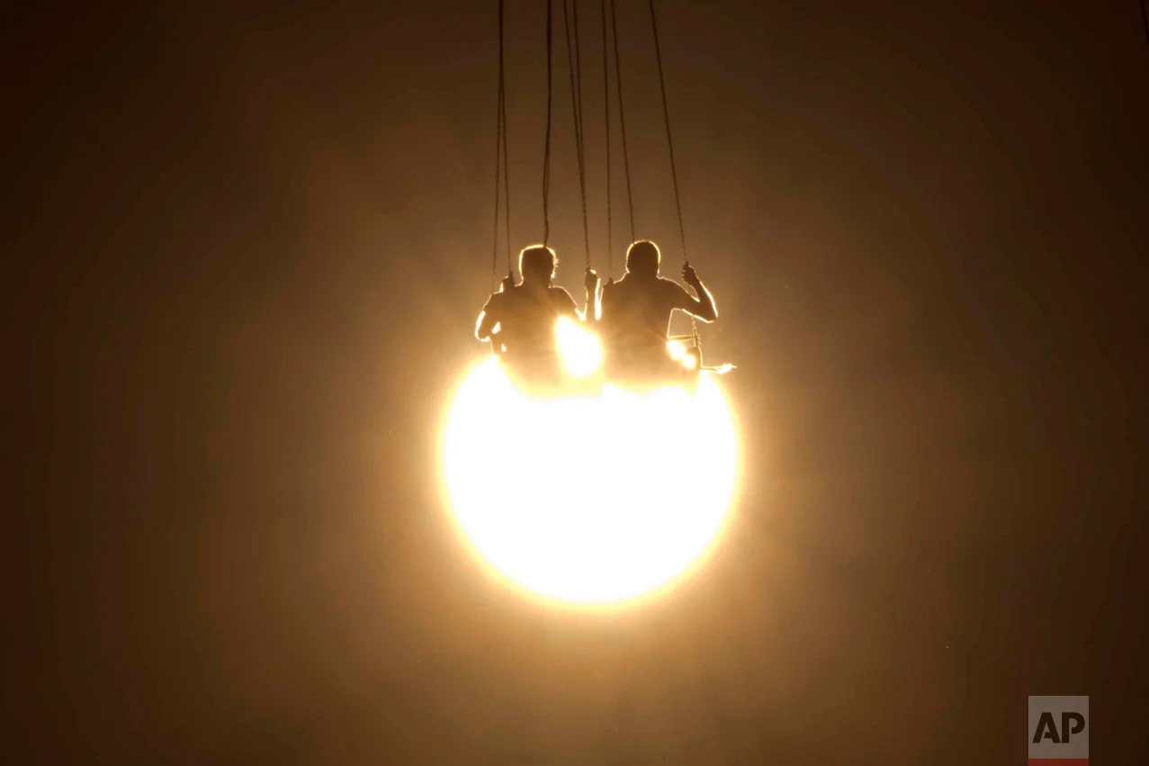 In this Wednesday, June 29, 2016 photo, people enjoy a chair swing ride as the sun sets at an amusement park, in Athens.(AP Photo/Petros Giannakouris)