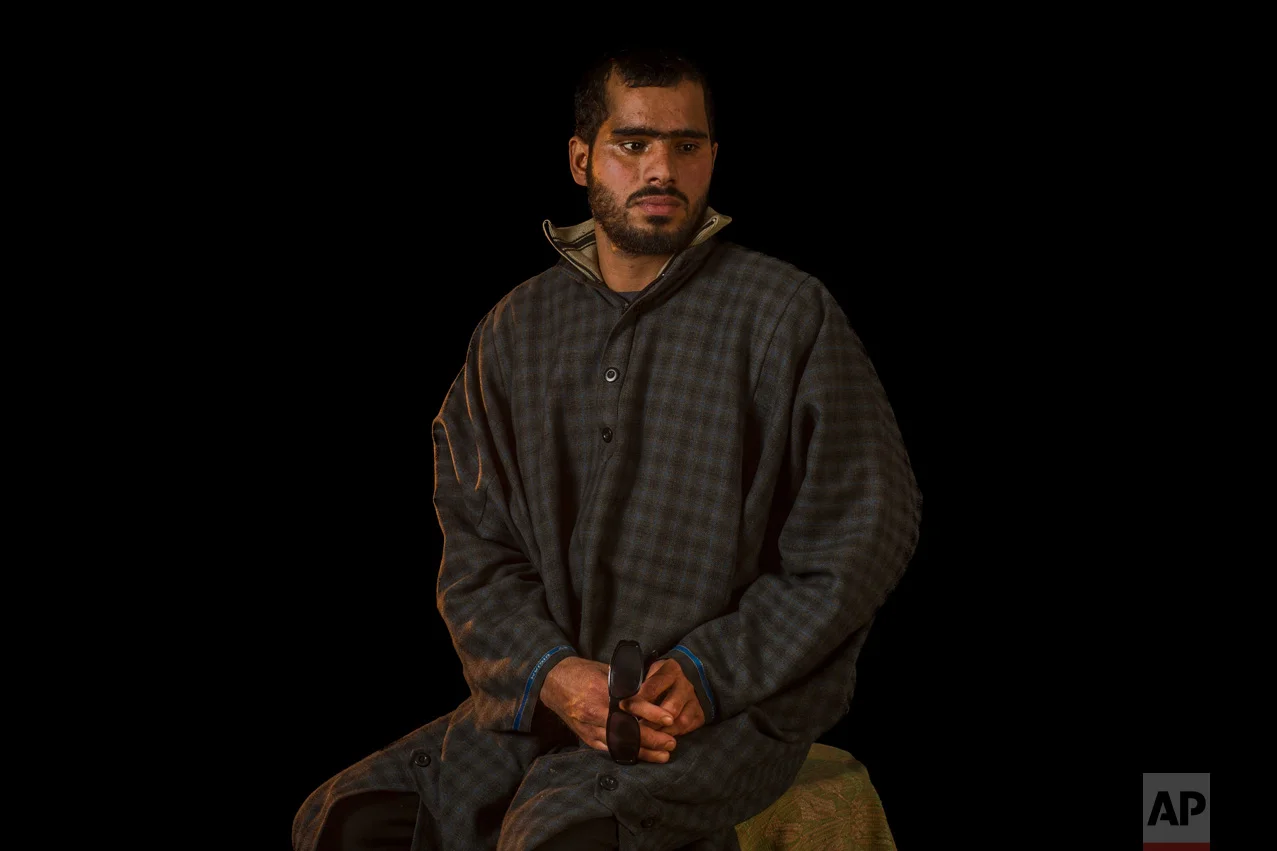 In this Dec. 2, 2016 photo, Manzoor Ah-Dar poses for a portrait in Rahmoo, district of Pulwama, Indian-controlled Kashmir. Manzoor was injured in both eyes by metal pellets when Indian forces raided the village. Health officials say that in the past five months more than 6,000 people, mostly young men, have been injured by shotgun pellets, including hundreds blinded in one or both eyes. International groups like Amnesty International and Human Rights Watch have called for an end to the use of shotguns. (AP Photo/Bernat Armangue)