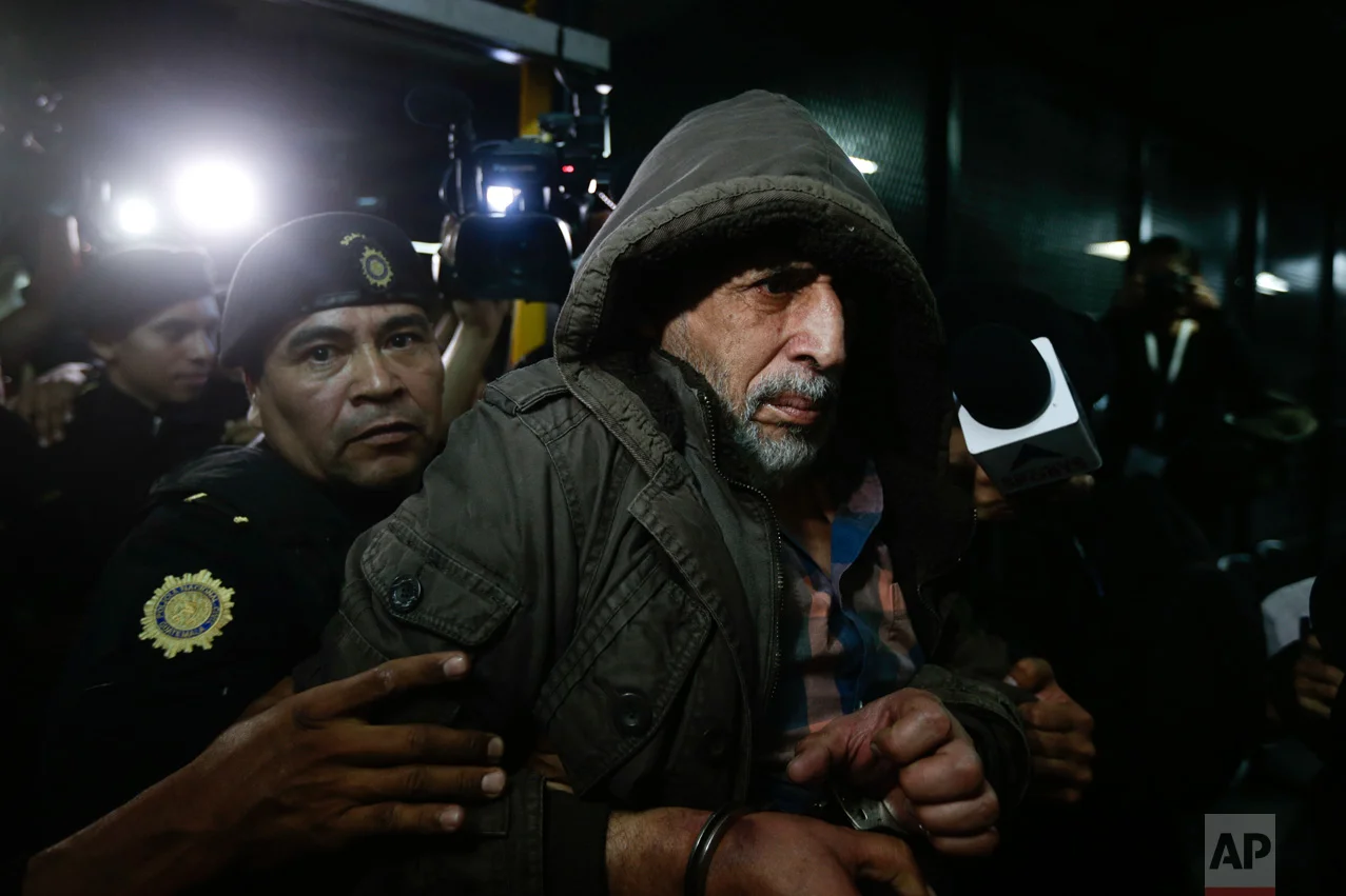 In this Jan. 12, 2016 photo, a handcuffed Brayan Jimenez, the former president of the Guatemalan football federation, is escorted by police into a courthouse in Guatemala City. Jimenez has been a fugitive for a month after Guatemala issued warrants for his arrest. Jimenez allegedly took a bribe to sell television rights to the 2018 World Cup qualifying matches. (AP Photo/Arnulfo Franco)