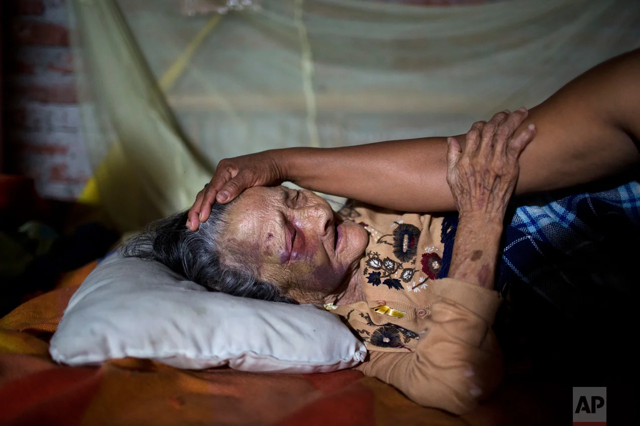 In this April 19, 2016 photo, Maria Victoria, 89, who was injured when a column fell on her after 7.8-magnitude earthquake collapsed her home, is comforted by her daughter Mariana in Estancia Las Palmas, Ecuador. President Rafael Correa had said the quake caused $3 billion in damage and warned that the reconstruction effort will take years. (AP Photo/Rodrigo Abd)