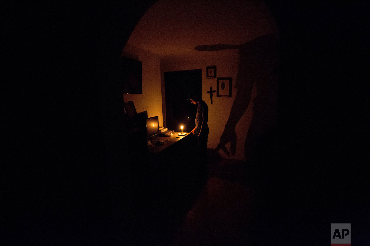  In this April 23, 2016 photo, a boy illuminates his home with a candle during a 24-hour blackout, in the El Calvario neighborhood of El Hatillo, just outside of Caracas, Venezuela. Energy rationing was added to the hardships faced by Venezuelans ove