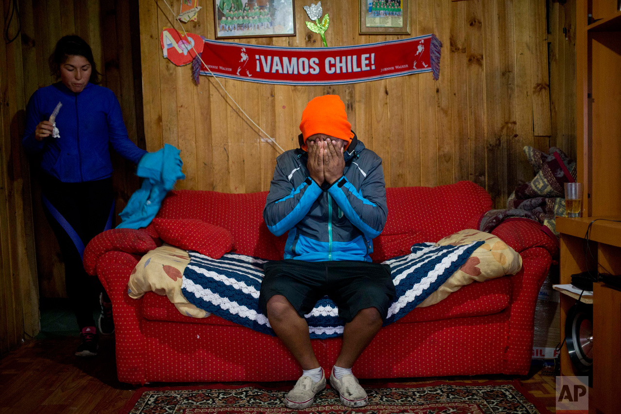  In this May 10, 2016 photo, diver Jose Luis Cifuentes covers his face in exhaustion and frustration inside his mother-in-law's home, saying he has no money to buy food, in Ancud, Chiloe Island, Chile, as the country faced its worst ever "red tide" e