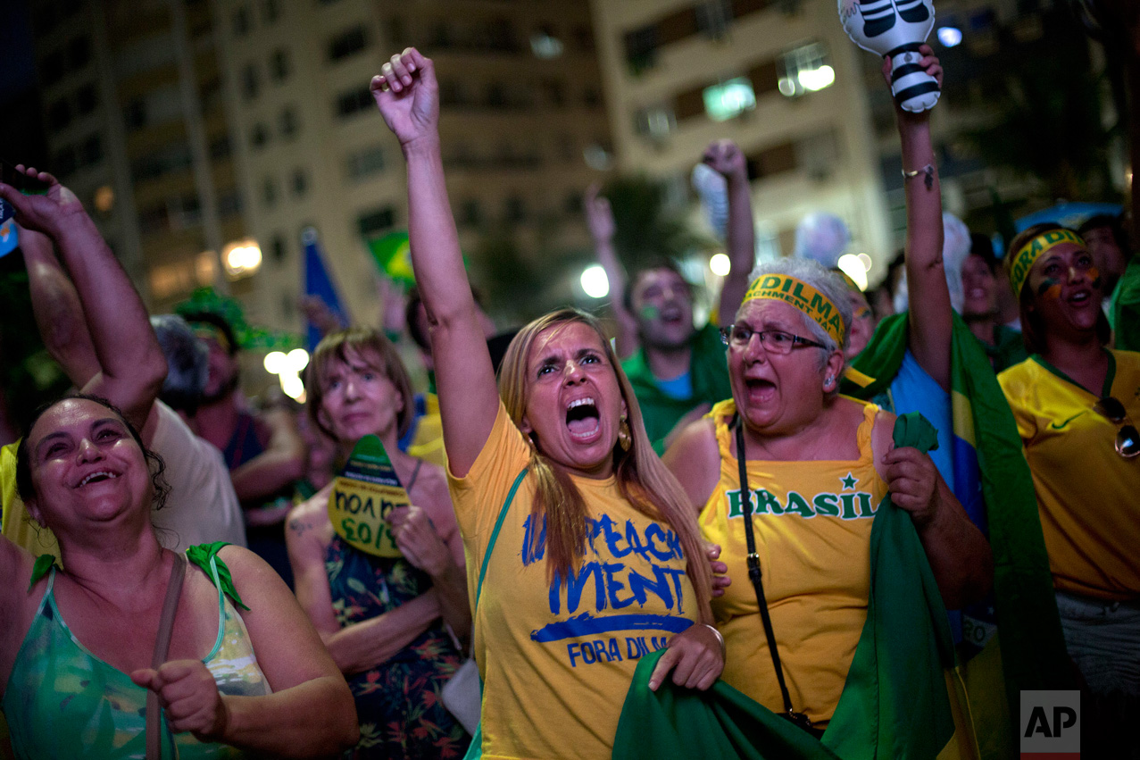  In this April 17, 2016 photo, anti-government demonstrators yell as they watch the vote count on a screen, as lawmakers vote on whether or not to impeach President Dilma Rousseff on Copacabana beach, in Rio de Janeiro, Brazil. The Chamber of Deputie