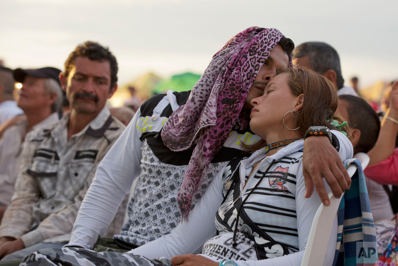  In this Sept. 26, 2016 photo, rebels of the Revolutionary Armed Forces of Colombia, FARC, embrace in Yari Plains, southern Colombia, as they watch the ceremony where President Juan Manuel Santos and FARC leader Rodrigo Londono, signed a peace accord