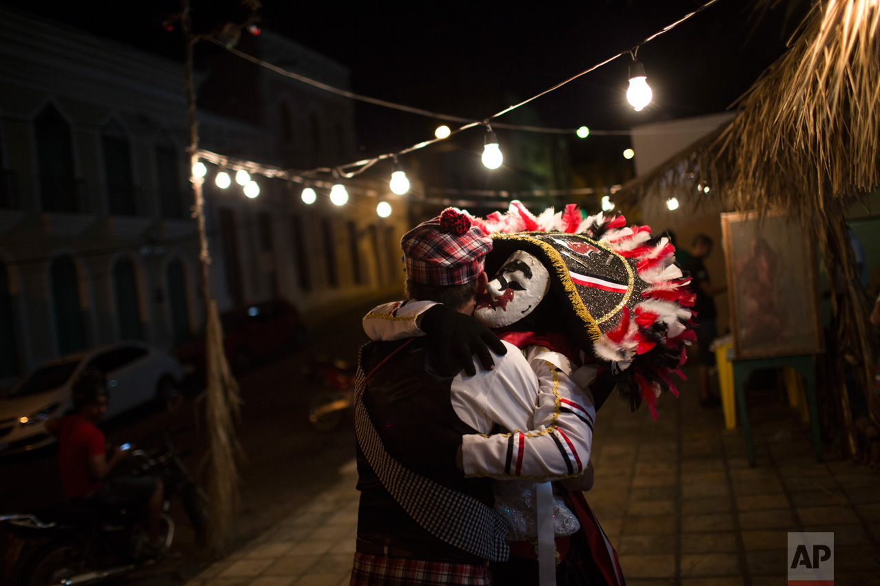  In this Feb. 8, 2016 photo, "Careta" embraces a reveler during Carnival in Triunfo, Brazil. Residents in this small town say the Careta tradition began after two men were forbidden to take part in a folk celebration due to their drunken behavior. As