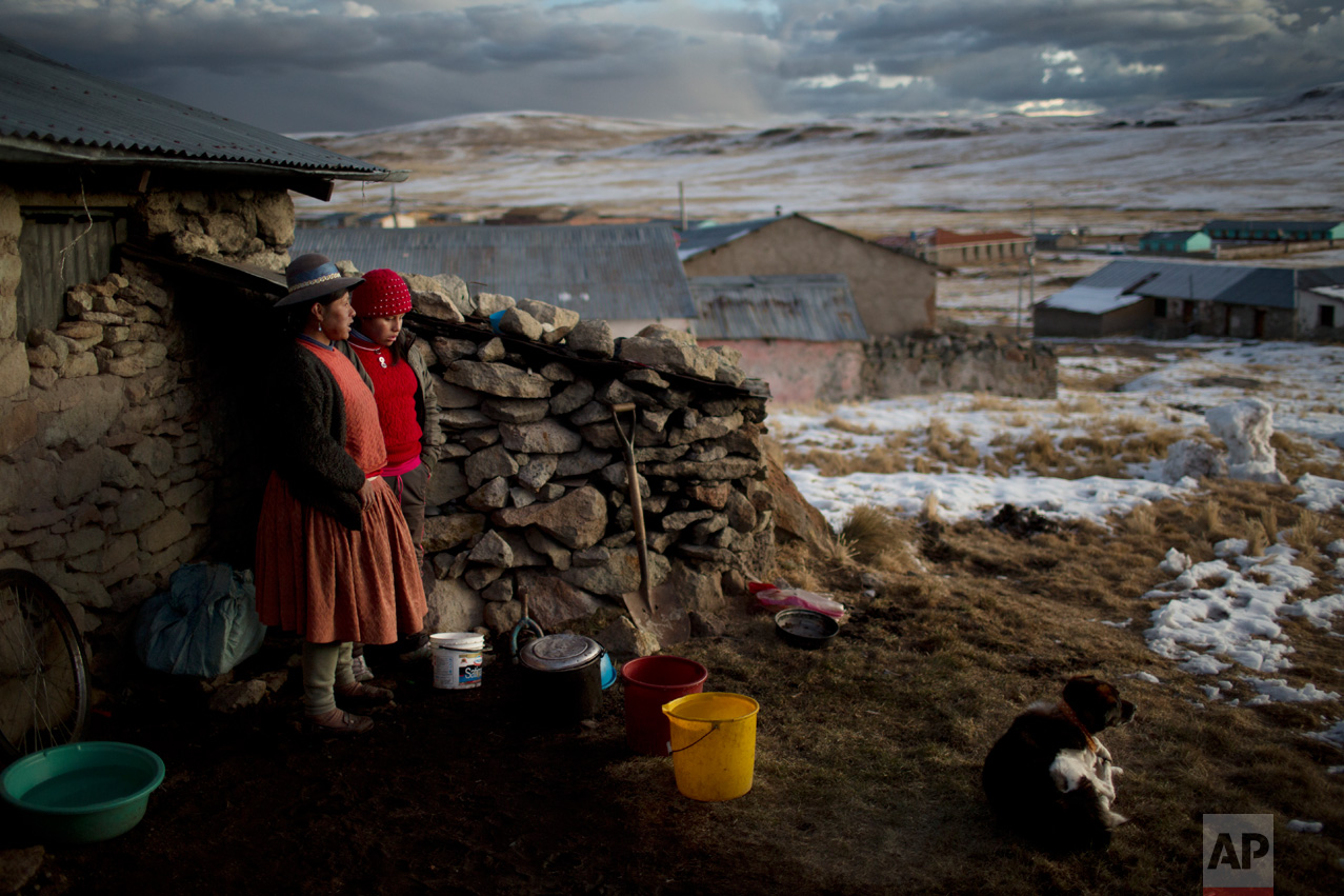  In this July 9, 2016 photo, Rosa Carcabusto, 29, and her daughter Maria Luque, 13, stand outside their house before preparing a soup of wheat and dissected potatoes for dinner in San Antonio de Putina, in Puno's region, Peru. In the villages located