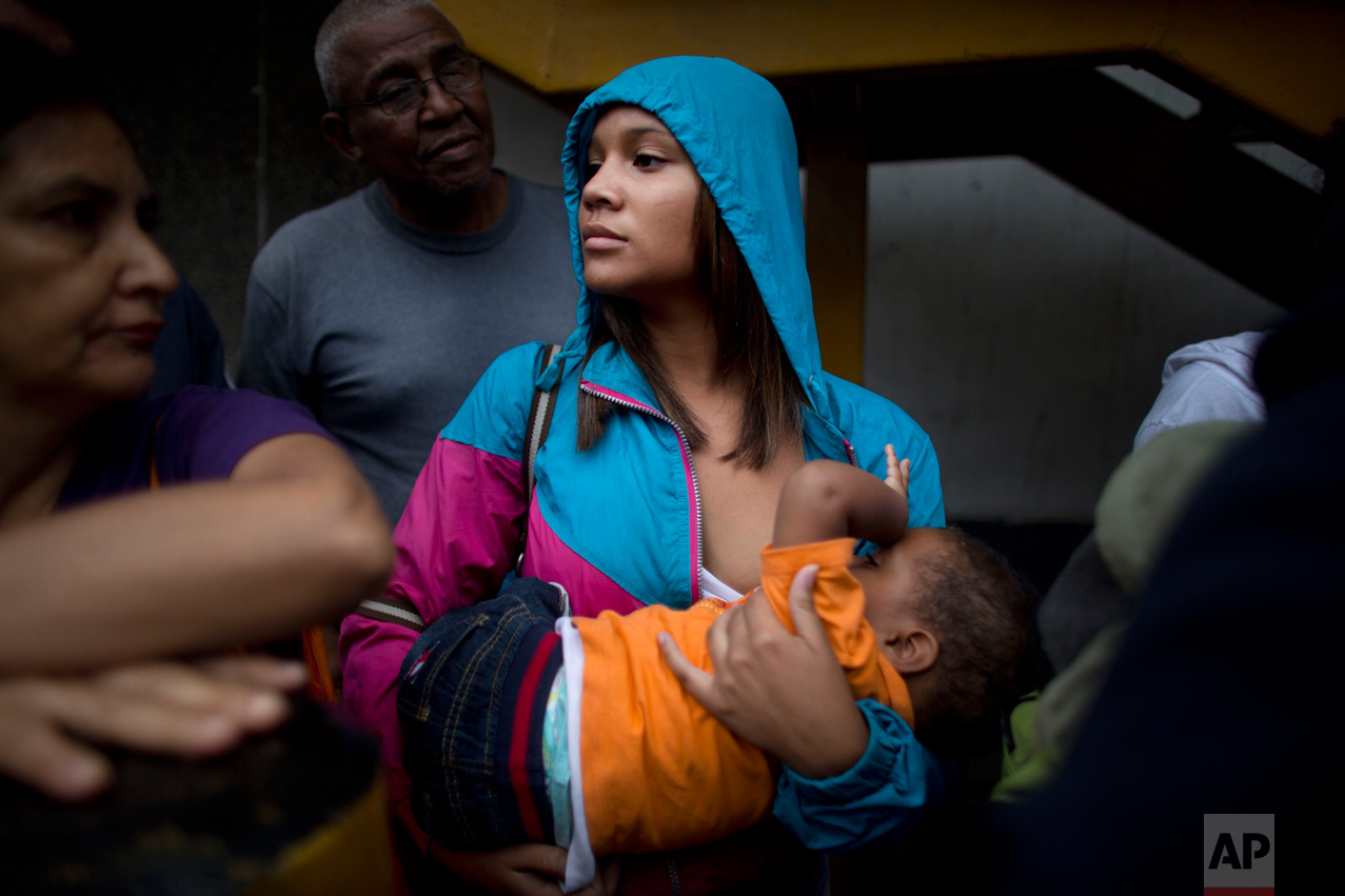  In this May 3, 2016 photo, 16-year-old Madeley Vasquez breastfeeds her one-year-old son Joangel as she waits in line outside a supermarket to buy food in Caracas, Venezuela. As Venezuela's lines grew longer and more dangerous, they became not only t