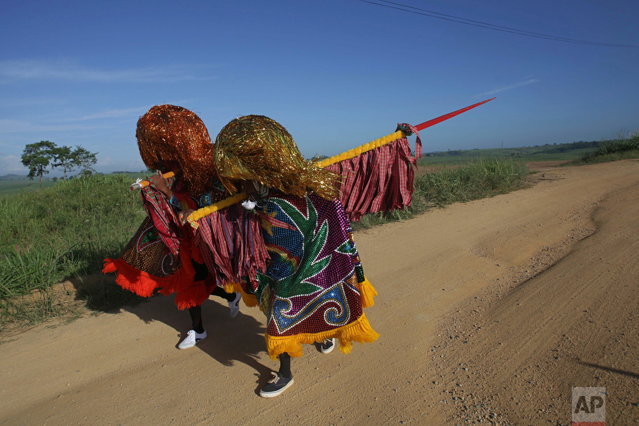  In this Feb. 7, 2016 photo, "Caboclo de Lanca," or lance-bearers, Nego Benvindo, left, and Jose Esteves, walk to town to take part in the Maracatu Carnival celebrations in Nazare da Mata, Brazil. The Afro-indigenous tradition is one of the oldest in