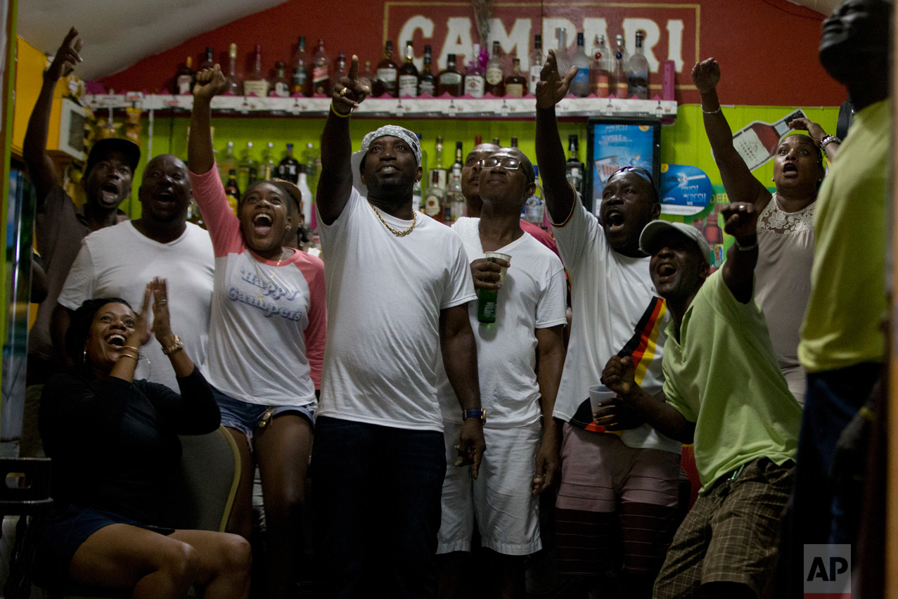  In this Aug. 14, 2016 photo, patrons watch Jamaica's Usain Bolt winning the Rio Olympics men's 100m final in Gros Islet, St. Lucia. (AP Photo/Ricardo Mazalan) 