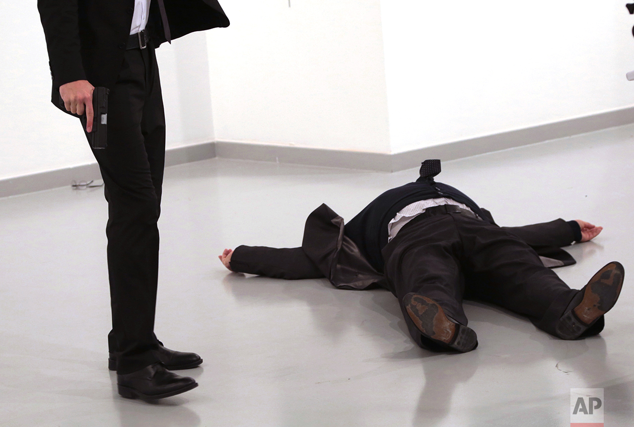 A man identified as Mevlut Mert Altintas holds the gun after shooting the Russian Ambassador to Turkey, Andrei Karlov, at a photo gallery in Ankara, Turkey, Monday, Dec. 19, 2016. A gunman opened fire on Russia's ambassador to Turkey at a photo exhibition on Monday. The Russian foreign ministry spokeswoman said he was hospitalized with a gunshot wound. (AP Photo/Burhan Ozbilici)