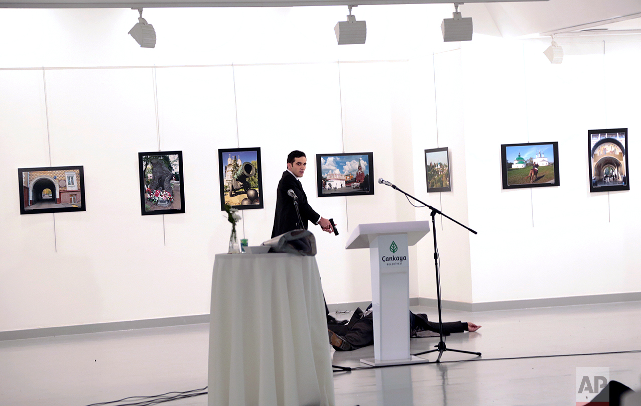 A man identified as Mevlut Mert Altintas shouts after shooting the Russian Ambassador to Turkey, Andrei Karlov, at a photo gallery in Ankara, Turkey, Monday, Dec. 19, 2016. (AP Photo/Burhan Ozbilici)