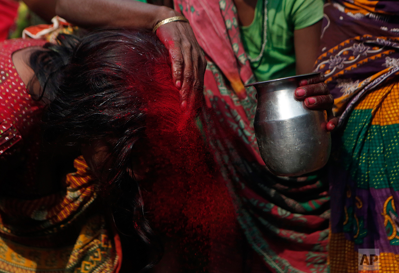 In this Wednesday, Nov. 23, 2016 photo, family members rinse out the red tikka powder, which is only allowed for married women, from the forehead of Saro Kumari Mandal, 26, after the death of her husband Balkisun Mandal Khatwe, 26, at Belhi village, in Saptari district, Nepal. Balkisun died in his sleep in Qatar, where he was working for Habtoor Leighton Group, loading trucks to build new highways. The number of Nepali workers going abroad has more than doubled since the country began promoting foreign labor in recent years: from about 220,000 in 2008 to about 500,000 in 2015. Yet the number of deaths among those workers has risen much faster in the same period. In total, over 5,000 workers from this small country have died working abroad since 2008, more than the number of U.S. troops killed in the Iraq War. (AP Photo/Niranjan Shrestha)