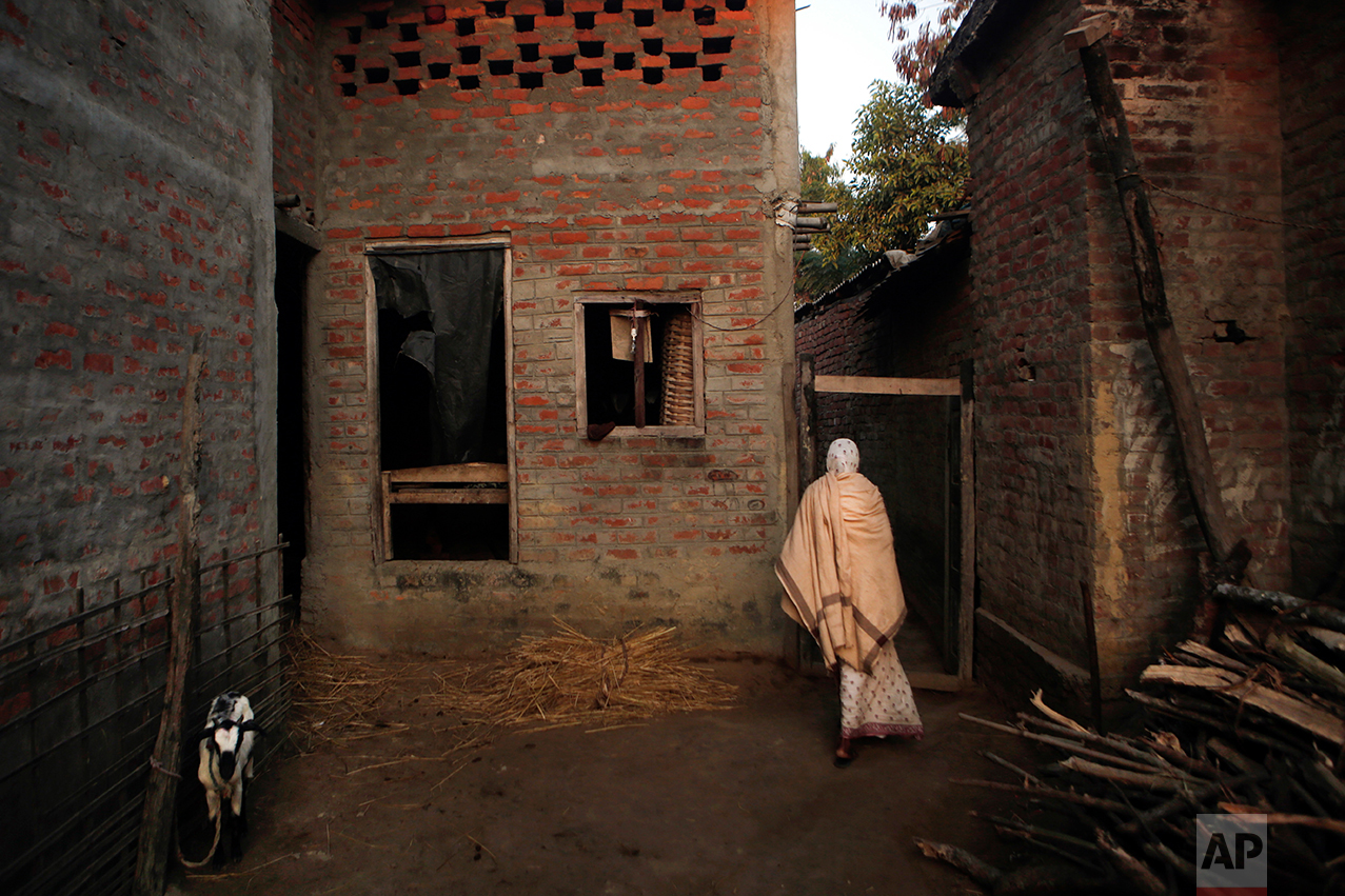 In this Wednesday, Nov. 30, 2016 photo, Saro Kumari Mandal, 26, whose husband died in his sleep as a migrant worker in Qatar, walks dressed in a white sari inside her home in Belhi village, Saptari district of Nepal. The number of Nepali workers going abroad has more than doubled since the country began promoting foreign labor in recent years: from about 220,000 in 2008 to about 500,000 in 2015. Yet the number of deaths among those workers has risen much faster in the same period. In total, over 5,000 workers from this small country have died working abroad since 2008, more than the number of U.S. troops killed in the Iraq War. Saro isn't allowed to remarry and will probably live on the edges of society, earning nothing more than some food to eat and a place to sleep. (AP Photo/Niranjan Shrestha)