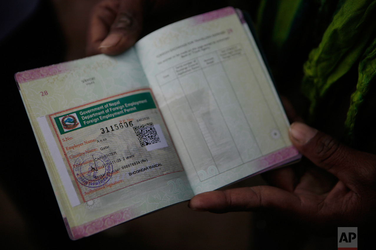 In this Nov 25, 2016 photo, a Nepalese man shows his passport with a working permit at the Department of Foreign Employment (DoFE) in Kathmandu, Nepal. The number of Nepali workers going abroad has more than doubled since the country began promoting foreign labor in recent years: from about 220,000 in 2008 to about 500,000 in 2015. The unskilled workers fill a host of global demands: building highways, stadiums and houses in Gulf states and guarding shopping malls, sewing sweatshirts and assembling televisions in Malaysia. (AP Photo/Niranjan Shrestha)