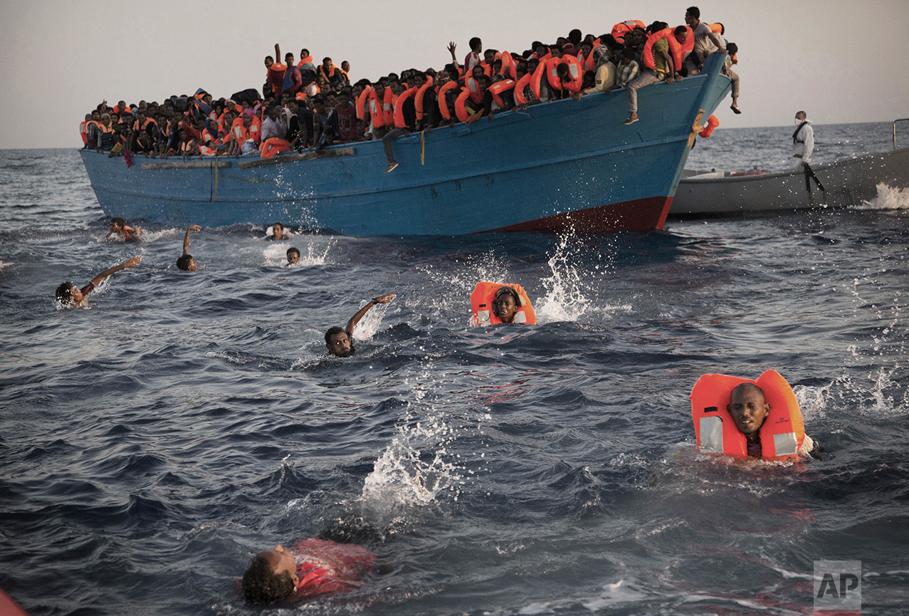  Migrants, most from Eritrea, jump into the water from a crowded wooden boat as they are helped by members of an NGO during a rescue operation in the Mediterranean sea, about 13 miles north of Sabratha, Libya, on Aug. 29, 2016. Thousands were rescued