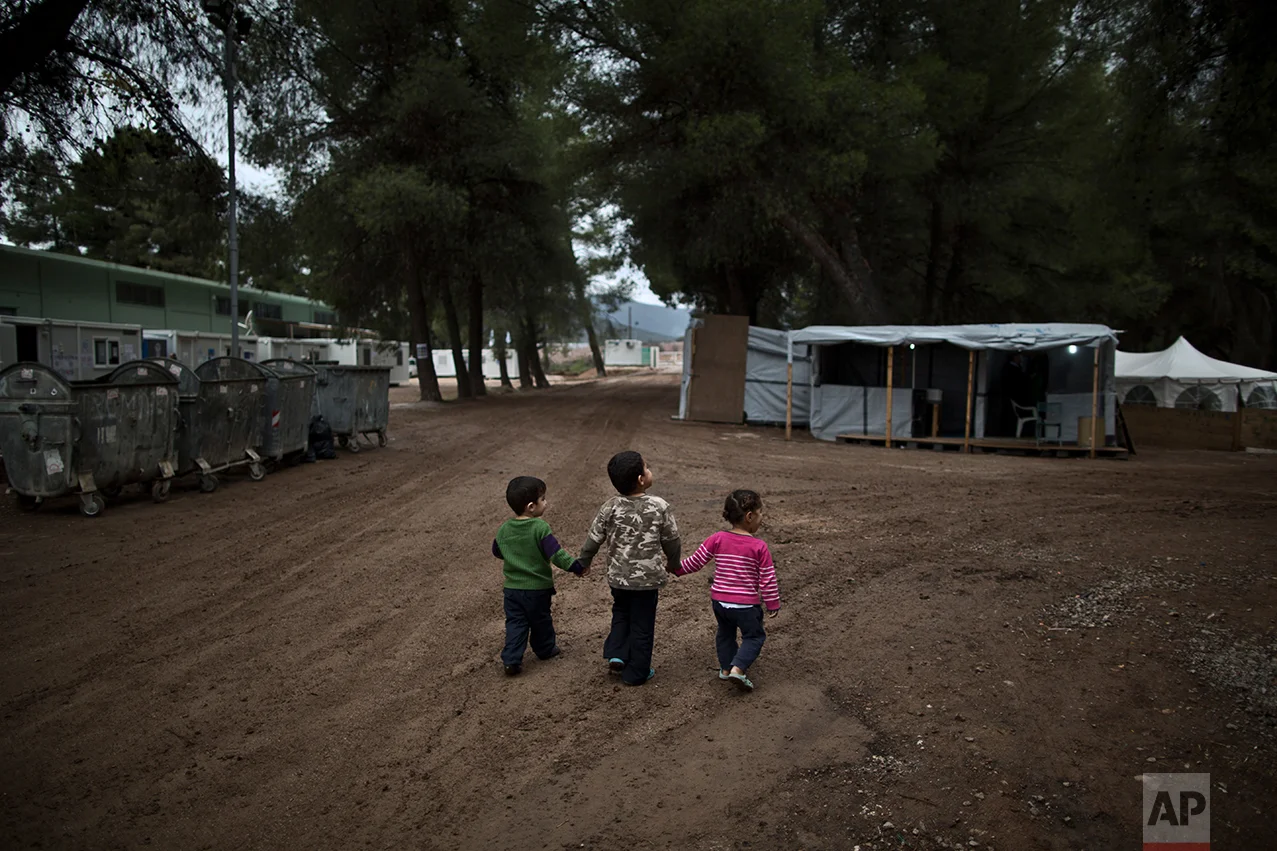 Syrian refugee children hold hands while walking in the refugee camp of Ritsona about 86 kilometers (53 miles) north of Athens, Wednesday, Dec. 28, 2016. (AP Photo/Muhammed Muheisen)
