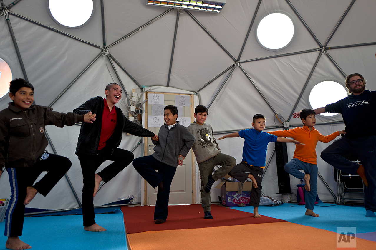  Afghan refugee children attend a yoga session during a class at a makeshift school in the refugee camp of Oinofyta about 58 kilometers (36 miles) north of Athens, Tuesday, Dec. 27, 2016. (AP Photo/Muhammed Muheisen) 
