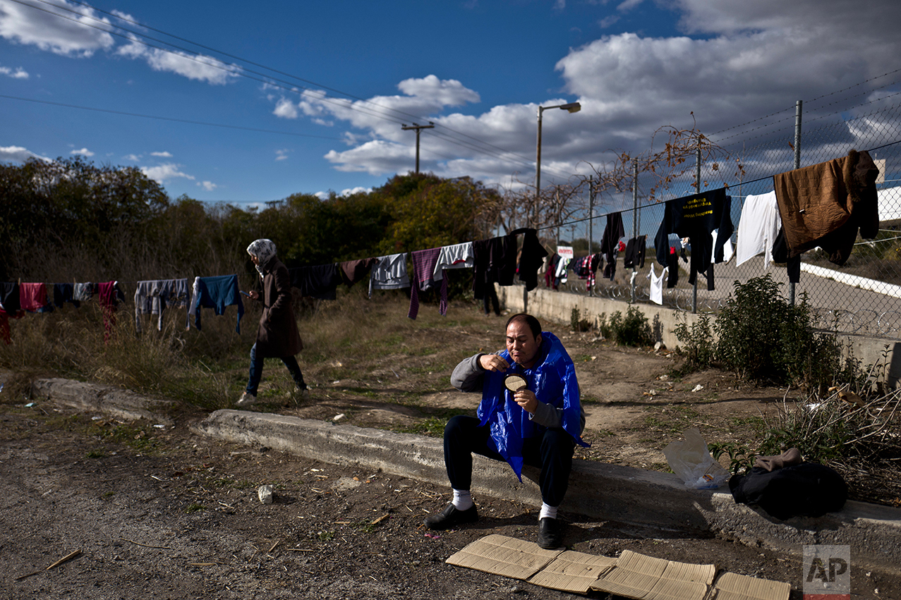 Afghan refugee Ghullam Tahiri, 40, trims his beard at the refugee camp of Oinofyta about 58 kilometers (36 miles) north of Athens, Monday, Dec. 26, 2016. (AP Photo/Muhammed Muheisen)