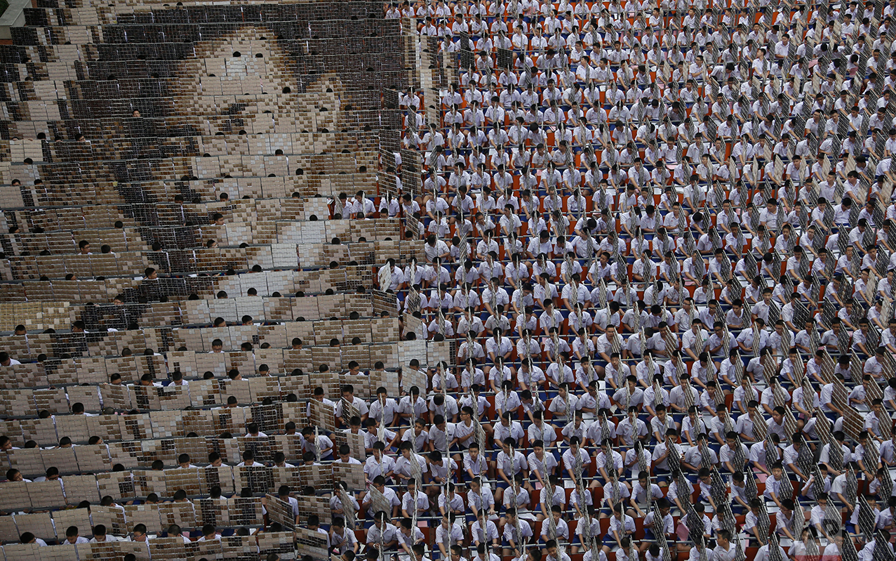  In this Oct. 28, 2016 photo, some 1,000 students practice flipping boards with photos to reveal a full-mosaic portrait of the late Thai King Bhumibol Adulyadej at Assumption College in Bangkok, Thailand. King Bhumibol died Oct. 13 after reigning for