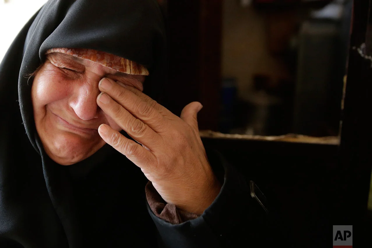 In this Sunday, Dec. 4, 2016 photo, Amina Hamawy cries after she returned to her looted home in the Hanano district of eastern Aleppo, Syria. (AP Photo/Hassan Ammar)