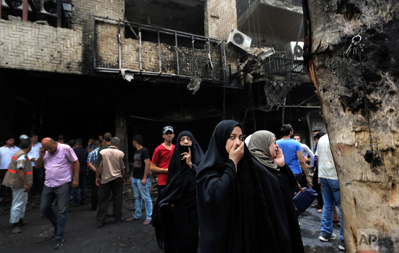 Iraqi women wait to hear about family members who went missing after a car bomb hit Karada, a busy shopping district in the center of Baghdad, Iraq, Sunday, July 3, 2016. (AP Photo/Hadi Mizban)