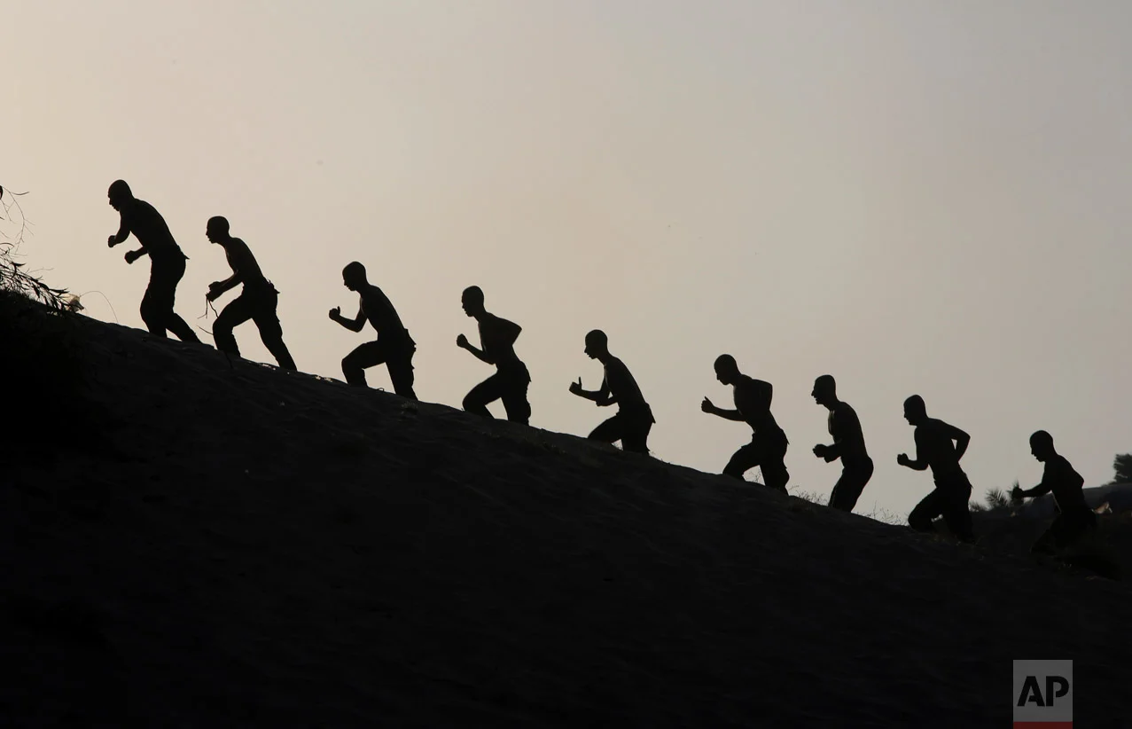 Palestinian students march during sunset in a display of their military skills at Al-Rebat College for Law and Police Science in Khan Younis, Gaza Strip, Tuesday, Sept. 20, 2016. Al-Rebat College for Law and Police Science was established by the Hamas government in 2009. The college has some 200 students who study for four years to join the security forces in Gaza strip. (AP Photo/Adel Hana)