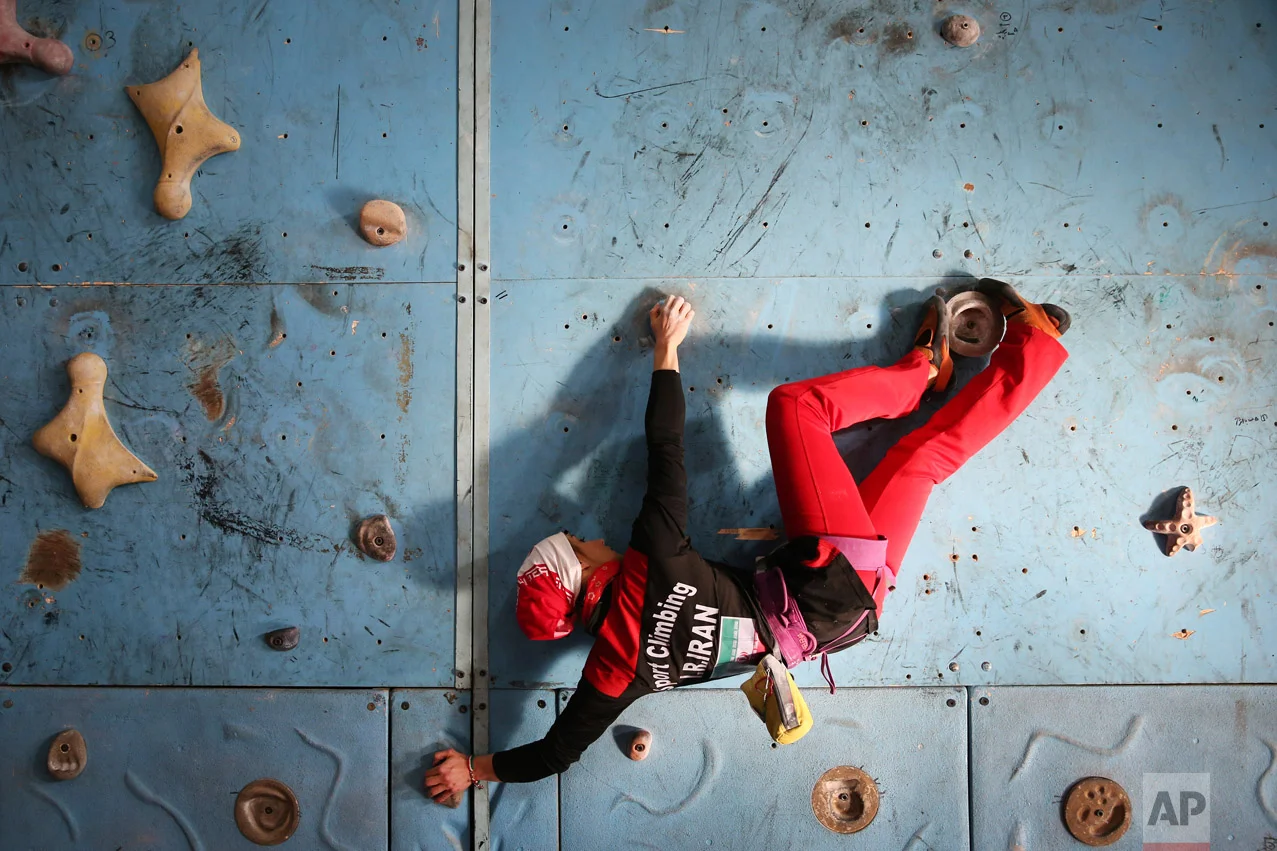 In this Monday, Jan. 18, 2016 photo, Iranian rock climber, Farnaz Esmaeilzadeh, scales a climbing gym in the city of Zanjan, some 330 kilometers (207 miles) west of the capital Tehran, Iran. Esmaeilzadeh, 27, who has been climbing since she was 13, has distinguished herself in international competitions despite the barriers she faces as a female athlete in conservative Iran. (AP Photo/Ebrahim Noroozi)