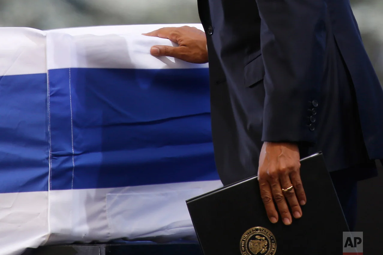 U.S. President Barack Obama touches the flag-draped coffin of former Israeli President Shimon Peres during his funeral at the Mount Herzel national cemetery in Jerusalem, Friday, Sept. 30, 2016. (AP Photo/Ariel Schalit)