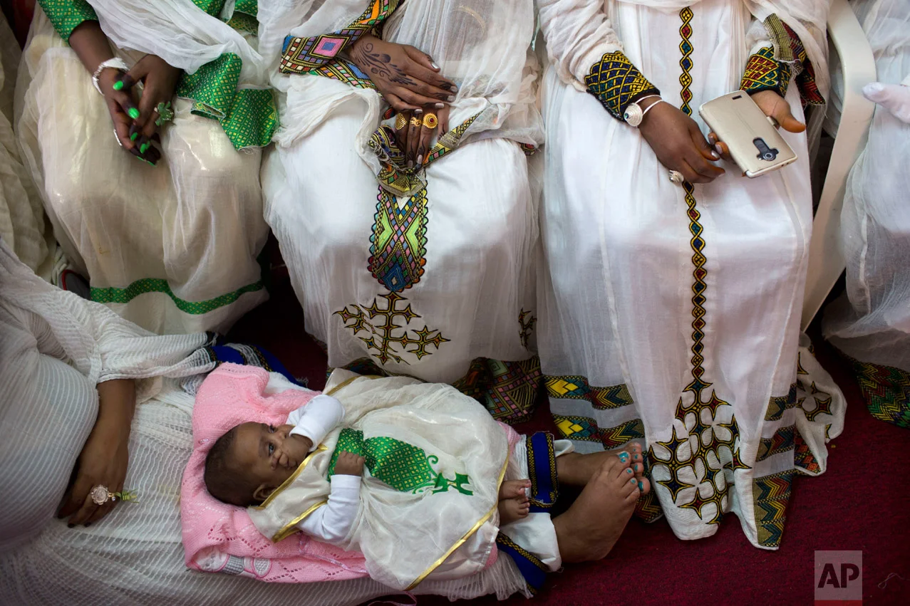 In this Saturday, April 23, 2016 photo, Eritrean Christian Orthodox migrant women attend a mass at a makeshift church in Tel Aviv, Israel. Hundreds of faithful gather each week in the makeshift churches. With its walls bedecked with Christian paraphernalia, it is an unlikely scene in the heart of the Jewish state, hidden in a non-descript building in hardscrabble south Tel Aviv. (AP Photo/Oded Balilty)
