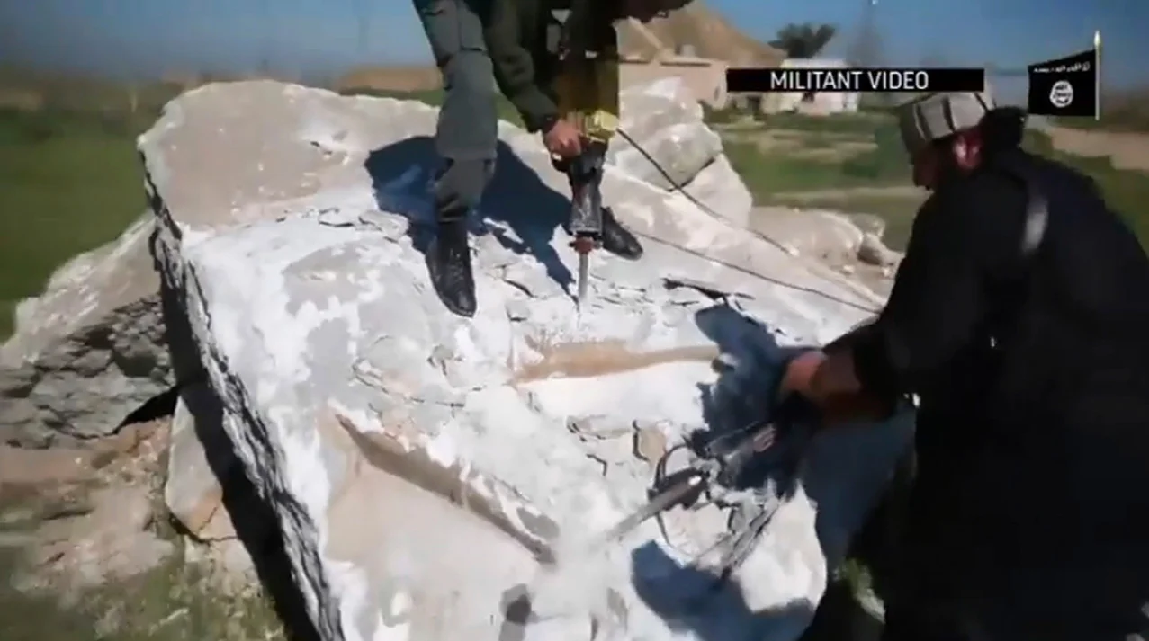 This image made from video posted online by Islamic State group militants in April 2015 shows militants using heavy tools to destroy a large stone figure of a lamasssu, an Assyrian winged bull deity at the ancient site of Nimrud near Mosul, Iraq. The militants boasted of their destruction of one of the Middle East’s most important archaeological sites in high-definition video propaganda, touting their campaign to purge their “caliphate” of anything they considered as heretical or pagan. (Militant video via AP)