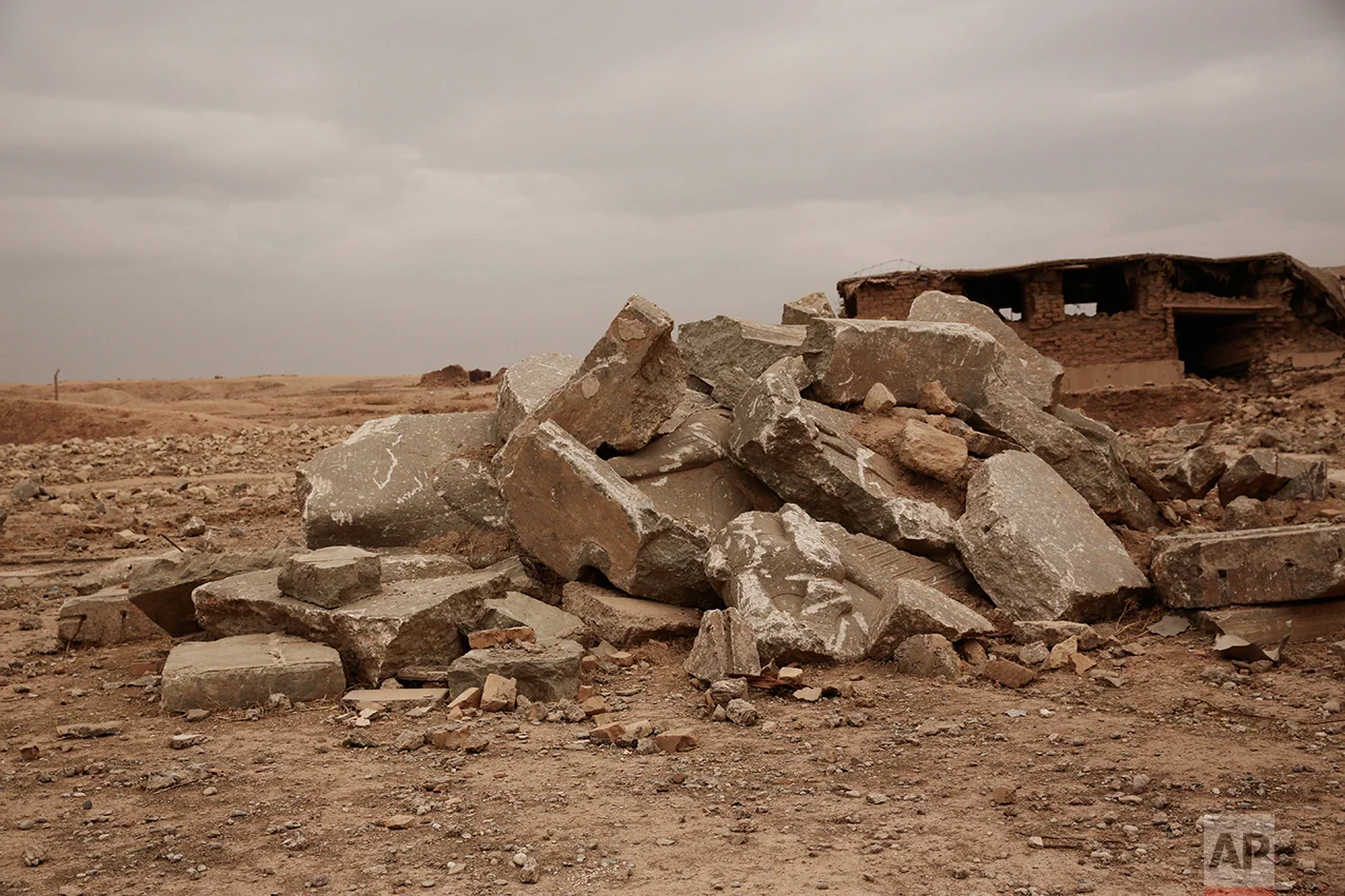 The remains of a large stone figure of a lamassu, an Assyrian winged bull deity, are piled near the gates of the ancient palace where they once stood at Nimrud, Iraq in this Wednesday, Dec. 14, 2016 photo. Islamic State group extremists detonated explosives throughout the palace, destroying its elaborate reliefs showing gods, mythical beasts and kings, and reducing it t a field of rubble. (AP Photo/Maya Alleruzzo)
