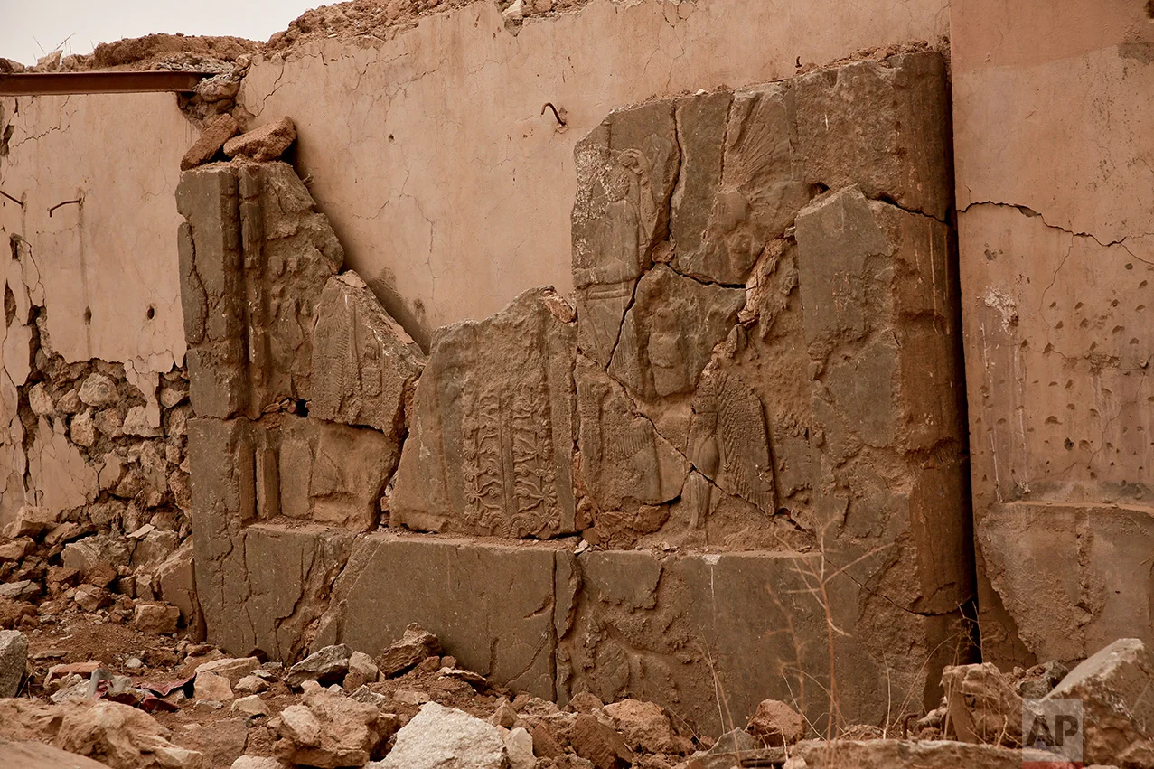 An ancient relief lies shattered in the Northwest Palace at the nearly 3,000-year-old site of Nimrud, Iraq, in this Wednesday, Dec. 14, 2016 photo. The destruction wreaked by Islamic State group militants at the site was extensive, leaving chunks of ancient reliefs, pieces of statues and pieces of cuneiform writing strewn amid rubble and dirt. With no protection more than a month after IS was driven out, those pieces are vulnerable to looting.(AP Photo/Maya Alleruzzo)
