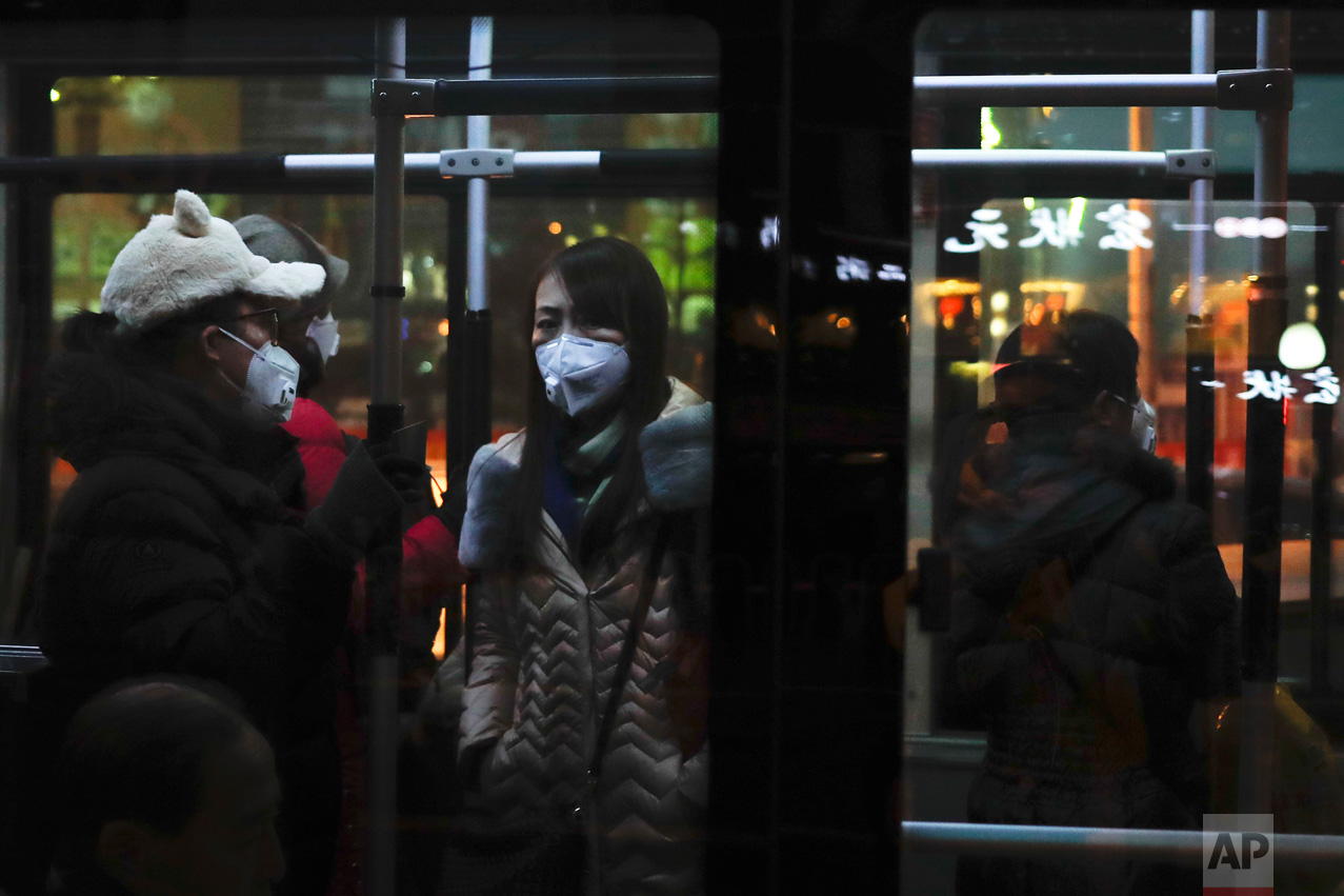 Passengers wearing masks stand inside a bus in Beijing as the Chinese capital is blanketed by smog on Friday, Dec. 30, 2016. China has long had some of the worst air in the world, blamed on its reliance on coal and a surplus of older, less efficient cars. It has set pollution reduction goals, but also has plans to increase coal mining capacity and eased caps on production when faced with rising energy prices. (AP Photo/Andy Wong)