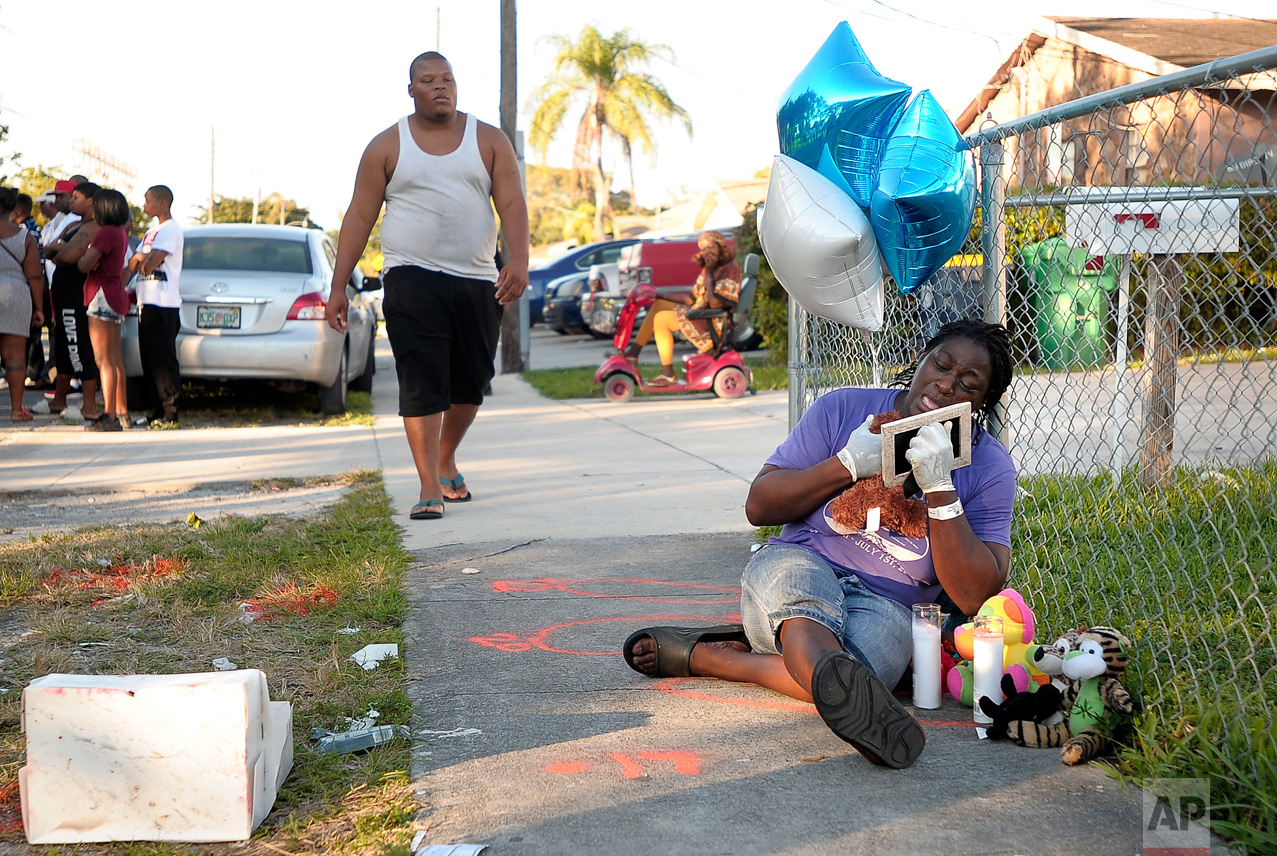 Caprice Cunningham cries on Thursday, Dec. 29, 2016 at the place where her grandson, Rasheed Cunningham, Jr., 8, was fatally shot in Dania Beach, Fla. On Friday, Broward Sheriff's Office announced an arrest in connection with the gun violence in Dania Beach that killed the 8-year-old boy on Wednesday, and Christopher Jordan, 25, on Christmas Day. (Michael Laughlin/South Florida Sun-Sentinel via AP)