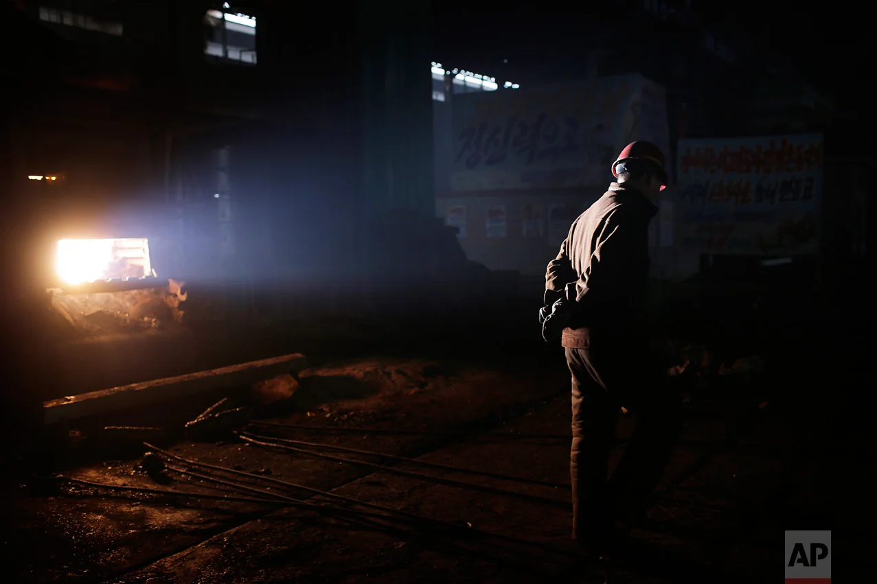 In this Saturday, Jan. 7, 2017 photo, a North Korean worker is illuminated by a shaft of light from a furnace at the Chollima Steel Complex in Nampo, North Korea. North Korean officials and factory managers are scrambling to answer a call from leader Kim Jong Un for an all-out, nationwide effort to build up the country’s economy in 2017. The sprawling Chollima complex south of Pyongyang, the capital, is a focal point of North Korea’s effort to expand the economy and lift the nation’s standard of living. One of seven North Korean steel works, Chollima has more than 8,000 workers and is among the North’s showcase enterprises. (AP Photo/Wong Maye-E)