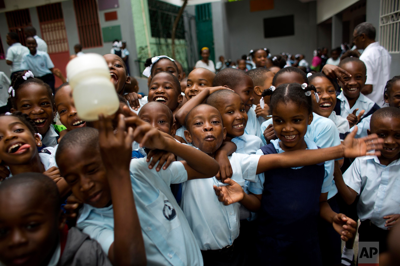 In this Jan. 9, 2017 photo, Judeley Hans Debel, center, and his classmates joke around at school in Petion-Ville, Haiti. Judeley, who hopes to study medicine when he's older, had his right leg amputated at the age of 2 ½ after his mother freed him from the rubble of the 2010 earthquake. (AP Photo/Dieu Nalio Chery)