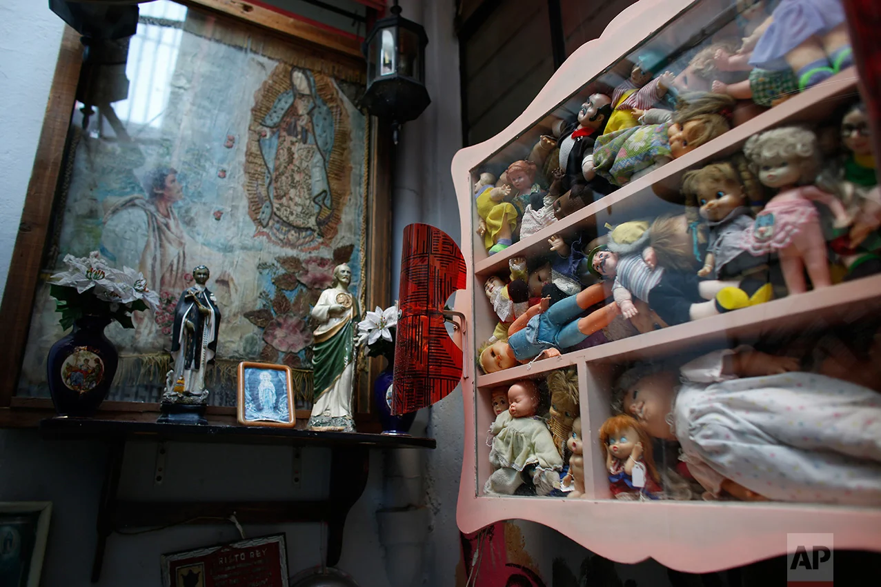 In this Jan. 11, 2017 photo, dolls stuff a display next to an altar to the Virgin of Guadalupe in the Mexico Antique Toy Museum in Mexico City. The museum is having to struggle following a congressional decision to stop allocating cultural funds for the collection. The museum has had to cut staff by half and most of its cultural events and workshops have been suspended, says the son, who hopes to raise money for the museum through a Kickstarter campaign.(AP Photo/Dario Lopez-Mills)