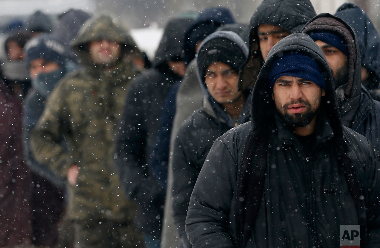 In this Tuesday, Jan. 10, 2017 photo, migrants queue for food in front of an abandoned warehouse in Belgrade, Serbia. (AP Photo/Darko Vojinovic)