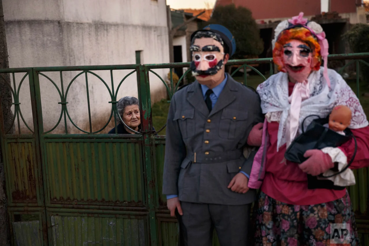 A couple dressed as characters from the movie "La Vaquilla" wear masks as they pose for a photo, during a winter masquerade gathering in Salsas, Portugal on Saturday, Jan. 7, 2017. Many of these masquerades are of ancient origin and can often be traced to pre-Christian Celtic and often pre-Roman traditions around the renewal of fertility and life and an end of winter. (AP Photo/Daniel Ochoa de Olza)