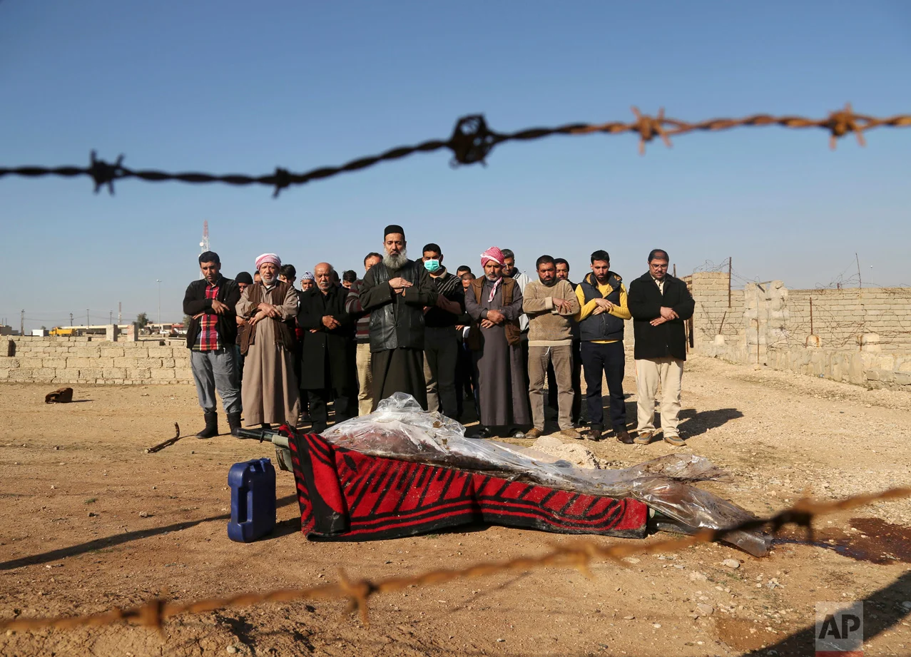 Mourners pray over the body of Musaap Yaser Hazem, 17, who died in an Islamic State mortar attack, during his funeral in Mosul, Iraq, Wednesday, Jan. 11, 2017. Hazem's father said his son was killed in early December 2016, and had to be buried in the neighborhood because of the poor security situation. With government forces making the area safer, the family was finally able to give Hazem a proper burial in the Mosul cemetery. (AP Photo/Khalid Mohammed)