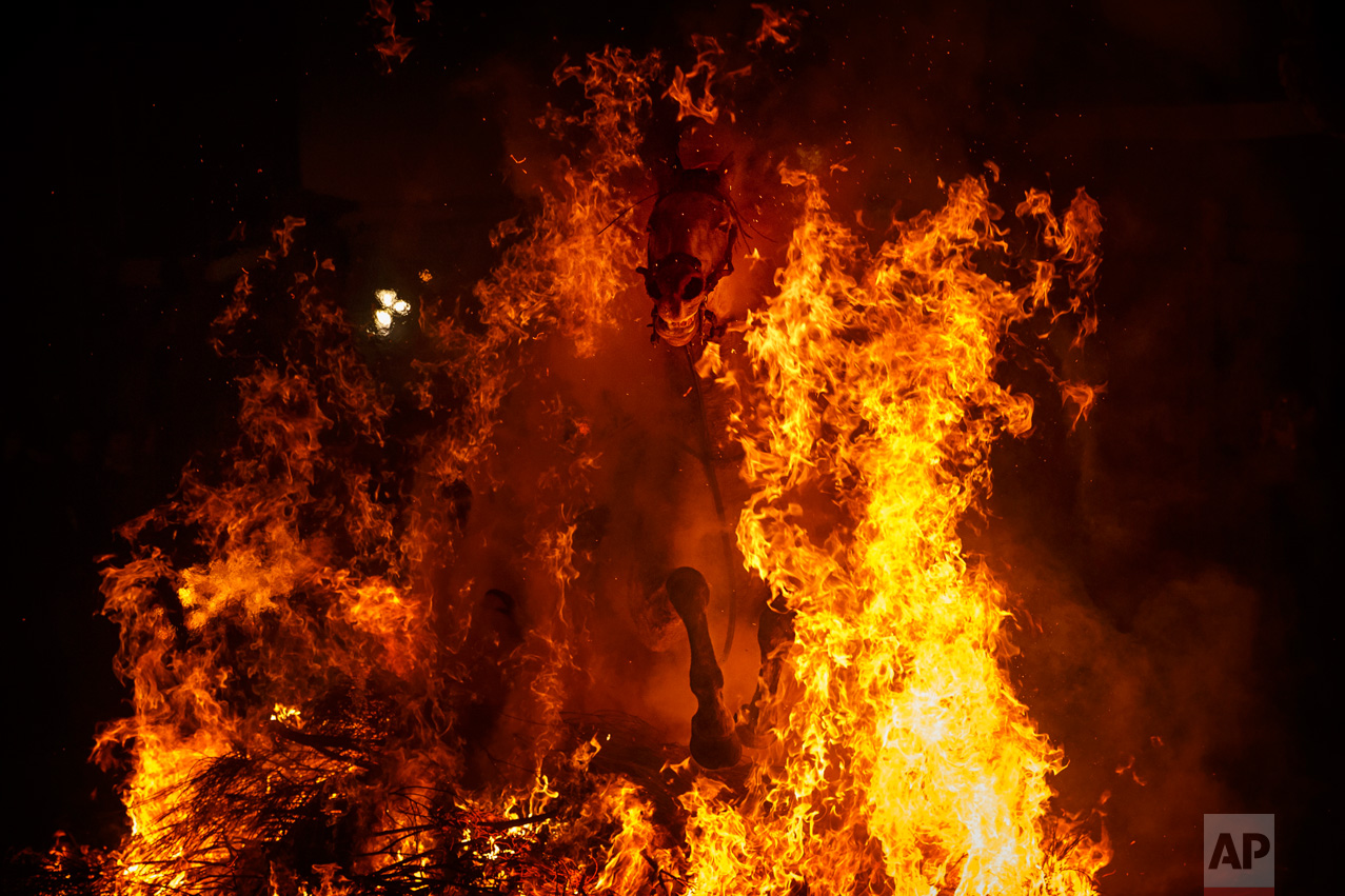 A man rides a horse through a bonfire as part of a ritual in honor of Saint Anthony the Abbot, the patron saint of domestic animals, in San Bartolome de Pinares, west of Madrid, Spain on Monday, Jan. 16, 2017. (AP Photo/Daniel Ochoa de Olza)