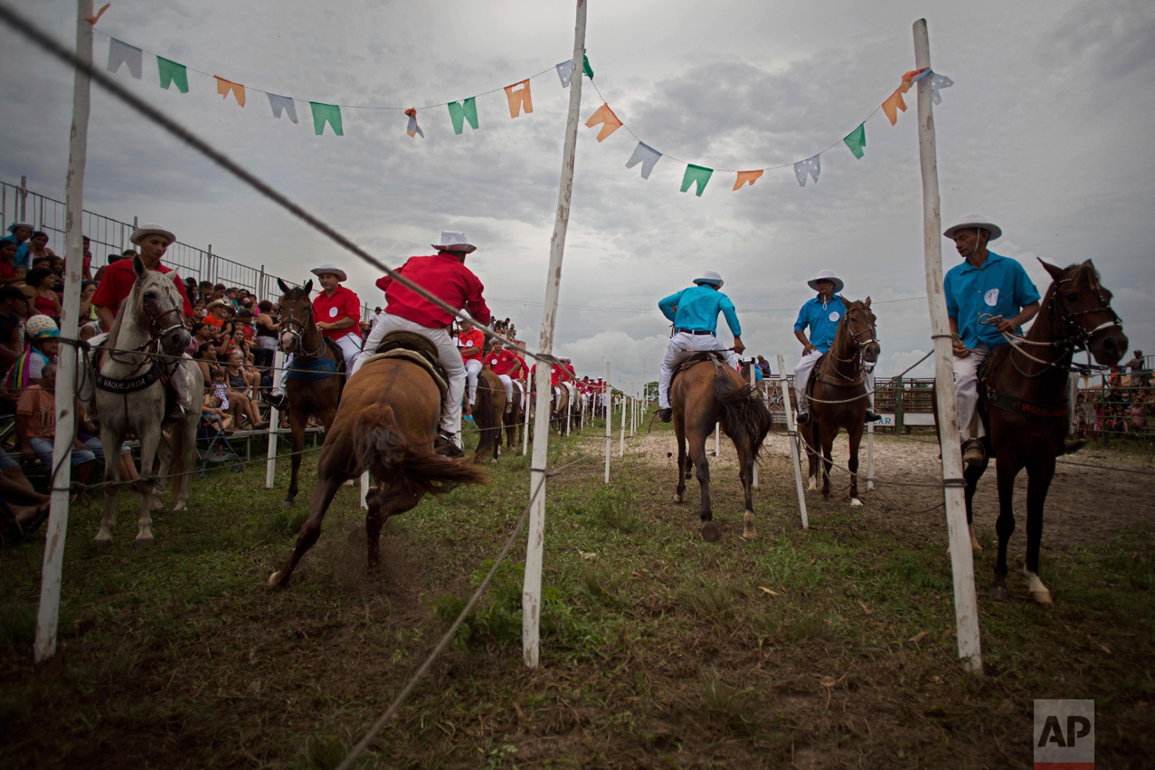 This Dec. 25, 2016 photo shows young cowboys competing in the Cavalhada, using small sticks and rings, during Marujada religious celebrations in honor of St. Benedict in the fishing town of Braganca, Brazil. Started in 1798, the "Marujada" religious celebration mixes indigenous, African and Portuguese traditions. (AP Photo/Eraldo Peres)